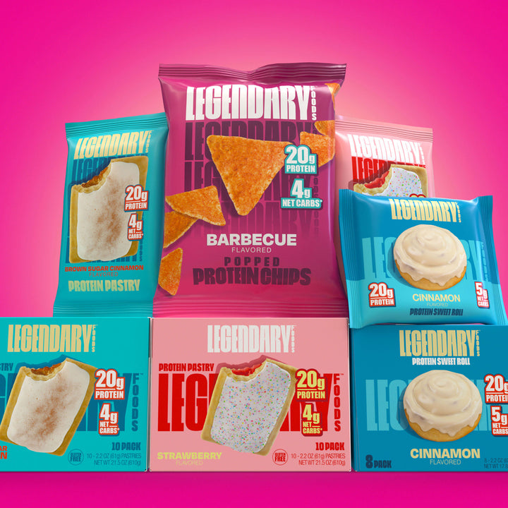 A colorful display of Legendary Foods products on a pink background, featuring Protein Pastries, Barbecue Protein Chips, and Cinnamon Sweet Rolls. The packaging highlights high protein (20g) and low net carbs (4–5g), targeting health-conscious buyers.