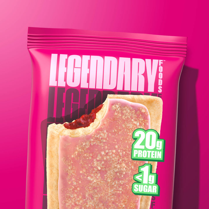 Close-up of Cherry Crumble protein pastry with a bite taken out, topped with pink icing and crumble. 20g protein, <1g sugar.